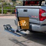 An eBike securely mounted on a rear hitch rack positioned on a car.