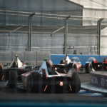 Formula E cars race through the indoor section of the London E‑Prix circuit at ExCeL London