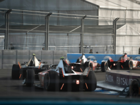 Formula E cars race through the indoor section of the London E‑Prix circuit at ExCeL London